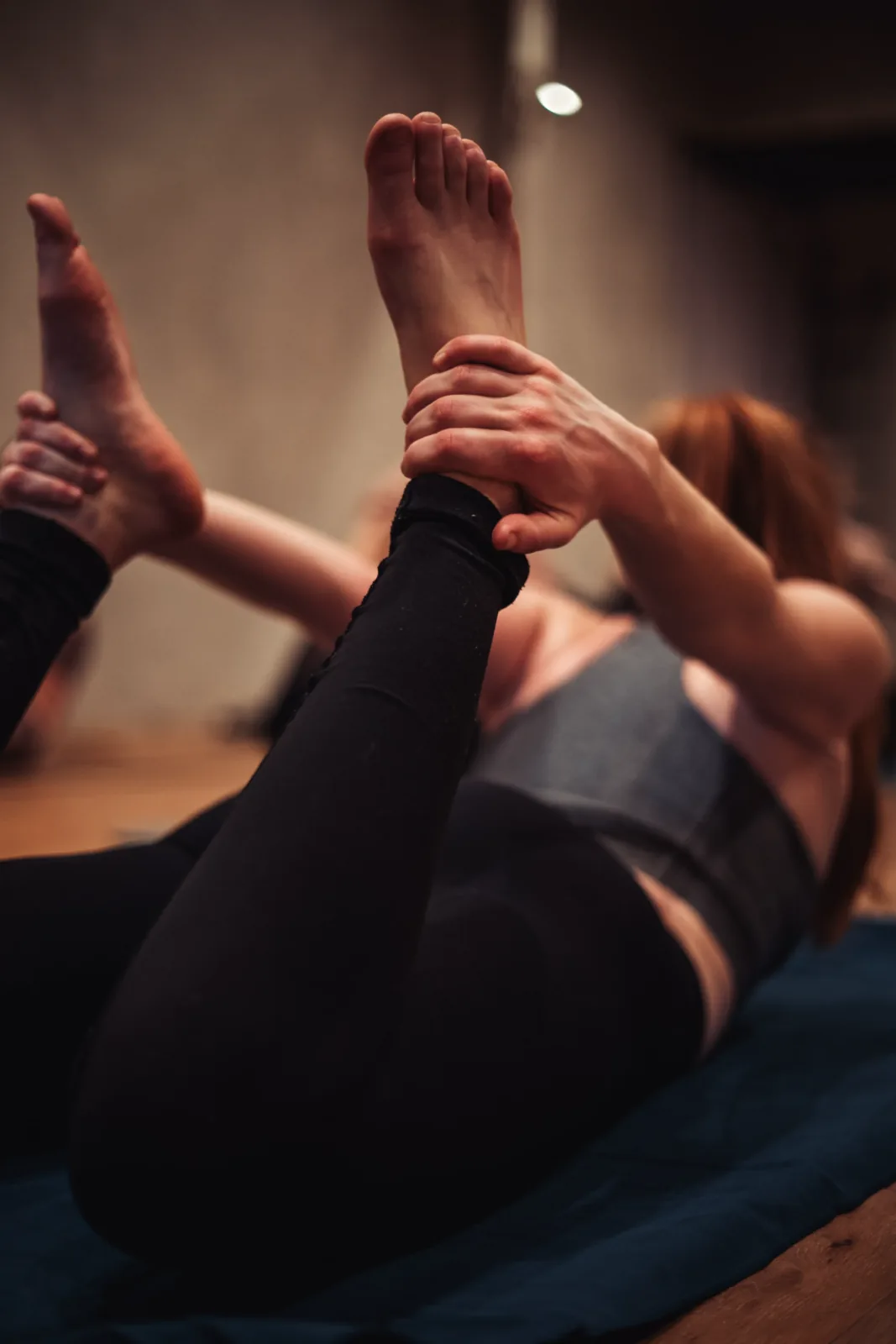 An instructor assisting a student with a foot stretch