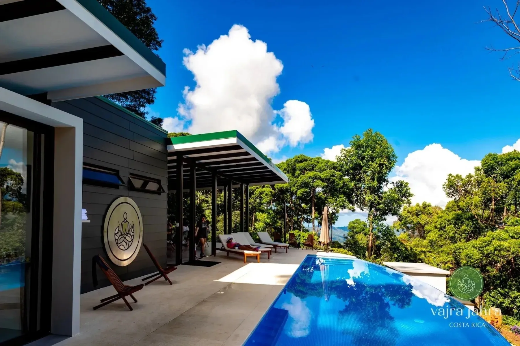 Pool and open-air retreat house surrounded by tropical greenery
