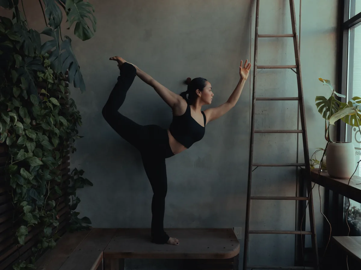 A student balancing in dancer pose at REWILD
